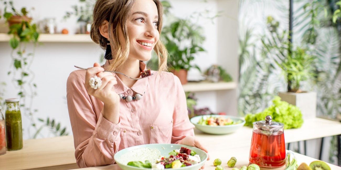 Femme à table mangeant un repas équilibré